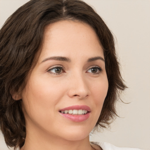 Joyful white young-adult female with medium  brown hair and green eyes