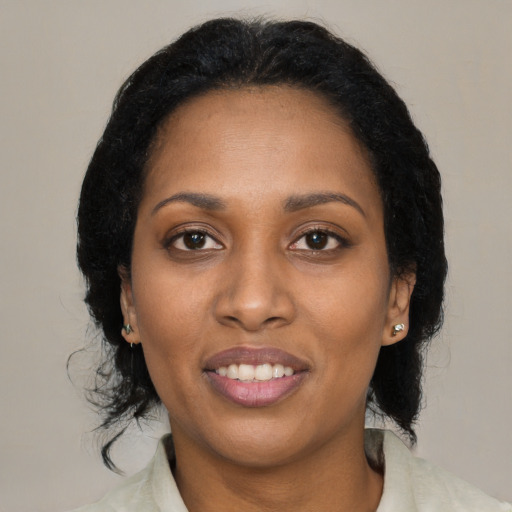 Joyful black young-adult female with medium  black hair and brown eyes
