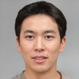 Joyful asian young-adult male with short  brown hair and brown eyes