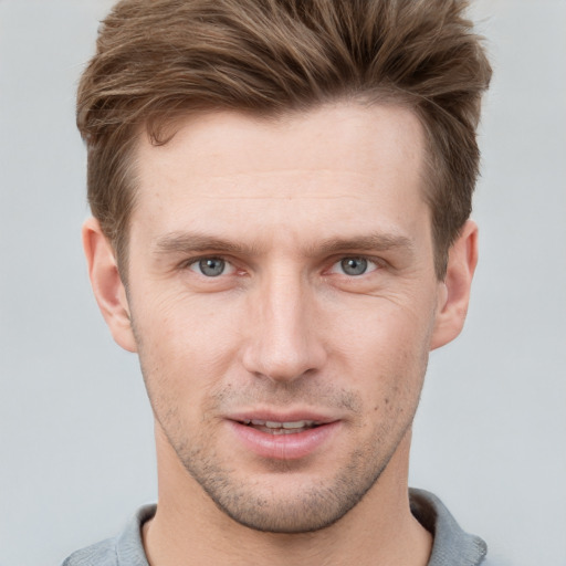 Joyful white young-adult male with short  brown hair and grey eyes