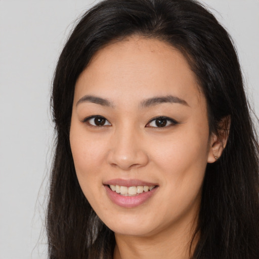 Joyful asian young-adult female with long  brown hair and brown eyes