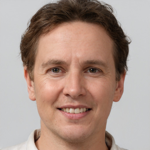 Joyful white adult male with short  brown hair and grey eyes