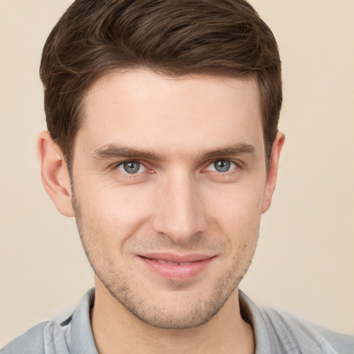 Joyful white young-adult male with short  brown hair and grey eyes