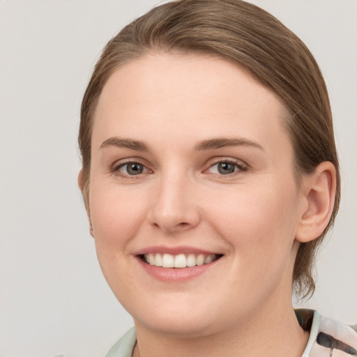 Joyful white young-adult female with medium  brown hair and grey eyes