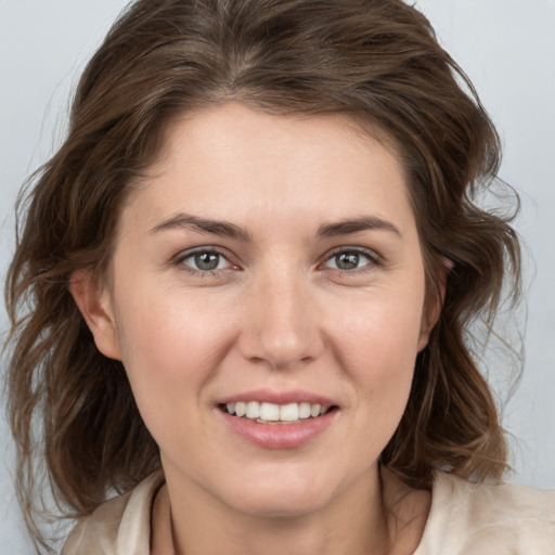 Joyful white young-adult female with medium  brown hair and grey eyes