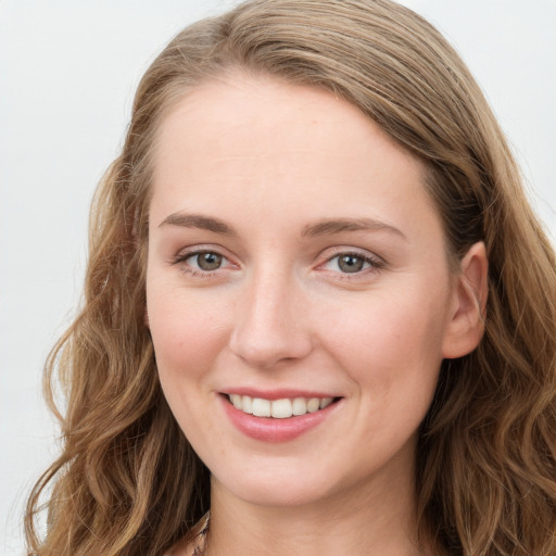 Joyful white young-adult female with long  brown hair and blue eyes