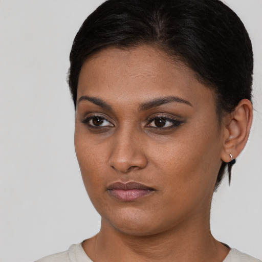 Joyful black young-adult female with short  black hair and brown eyes