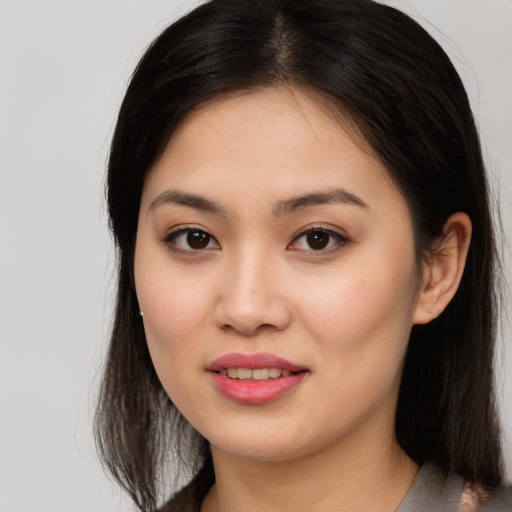 Joyful asian young-adult female with long  brown hair and brown eyes