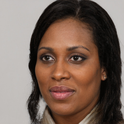 Joyful black young-adult female with long  black hair and brown eyes