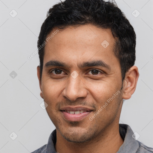 Joyful latino young-adult male with short  black hair and brown eyes