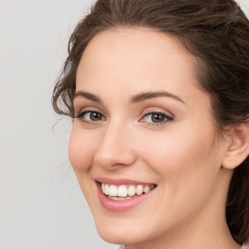 Joyful white young-adult female with long  brown hair and green eyes