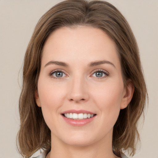 Joyful white young-adult female with medium  brown hair and green eyes