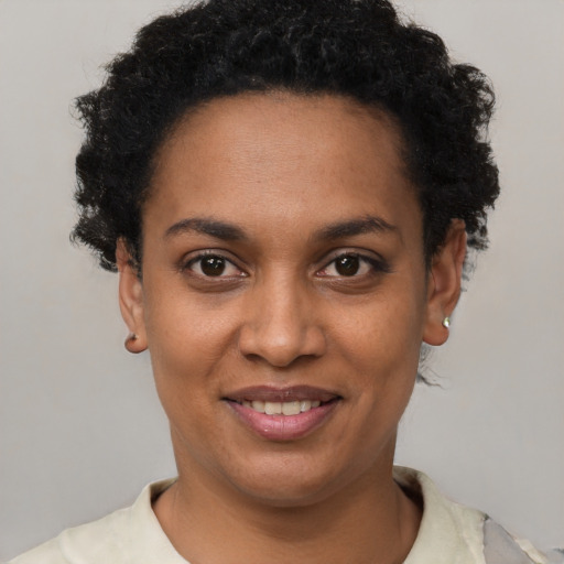 Joyful black young-adult female with short  brown hair and brown eyes