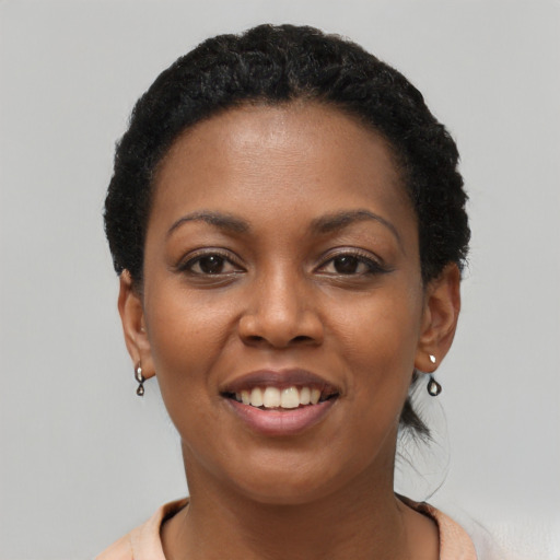 Joyful black young-adult female with short  black hair and brown eyes