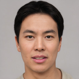 Joyful asian young-adult male with short  black hair and brown eyes