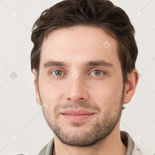 Joyful white young-adult male with short  brown hair and grey eyes