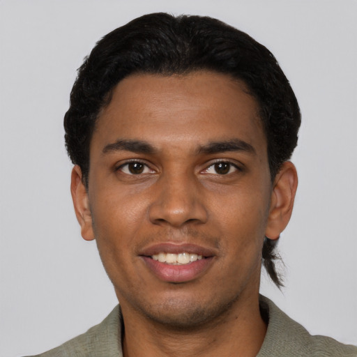 Joyful black young-adult male with short  black hair and brown eyes