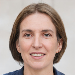 Joyful white adult female with medium  brown hair and grey eyes