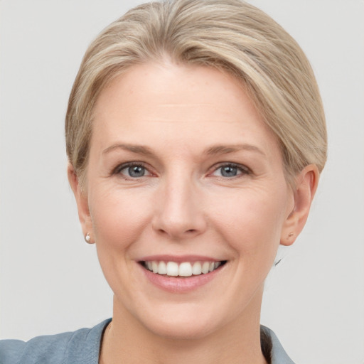 Joyful white young-adult female with short  brown hair and grey eyes