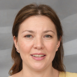 Joyful white adult female with medium  brown hair and blue eyes