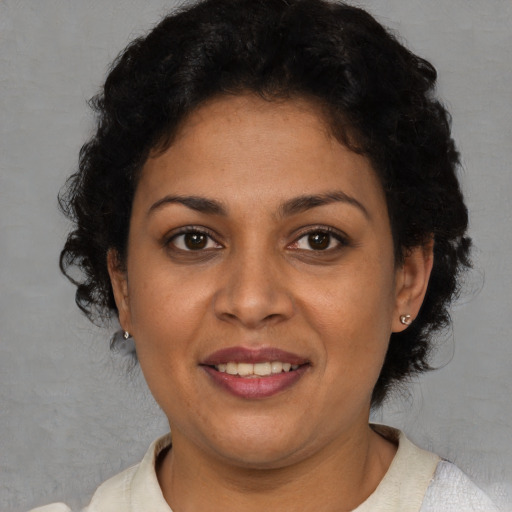 Joyful latino adult female with short  brown hair and brown eyes