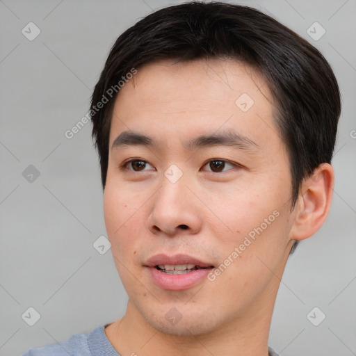 Joyful asian young-adult male with short  brown hair and brown eyes