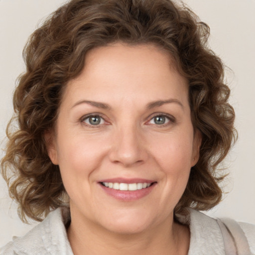 Joyful white adult female with medium  brown hair and green eyes