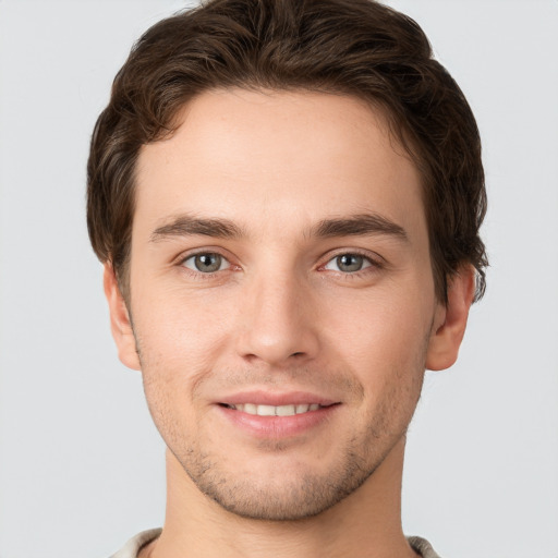 Joyful white young-adult male with short  brown hair and grey eyes