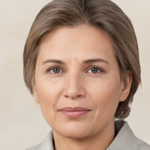 Joyful white adult female with medium  brown hair and brown eyes