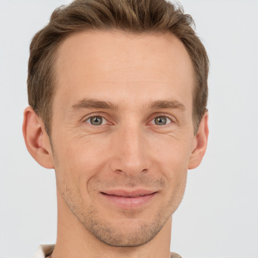 Joyful white adult male with short  brown hair and grey eyes