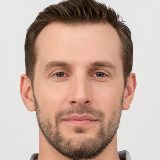 Joyful white young-adult male with short  brown hair and brown eyes