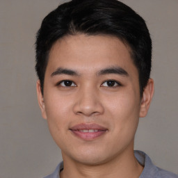 Joyful asian young-adult male with short  black hair and brown eyes