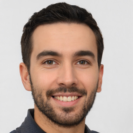 Joyful white young-adult male with short  black hair and brown eyes