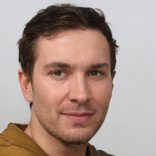 Joyful white young-adult male with short  brown hair and grey eyes