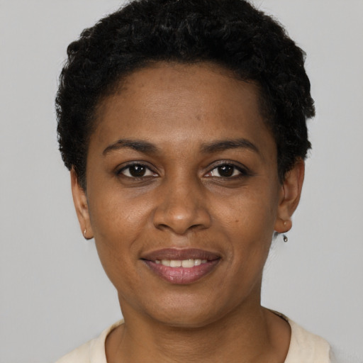 Joyful black young-adult female with short  black hair and brown eyes