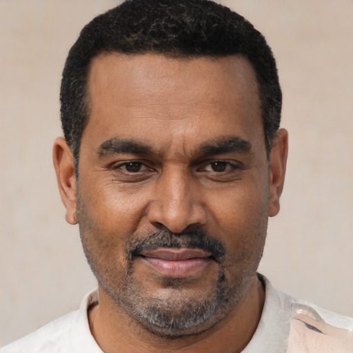 Joyful latino adult male with short  black hair and brown eyes