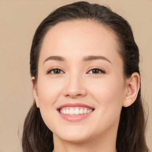 Joyful white young-adult female with long  brown hair and brown eyes