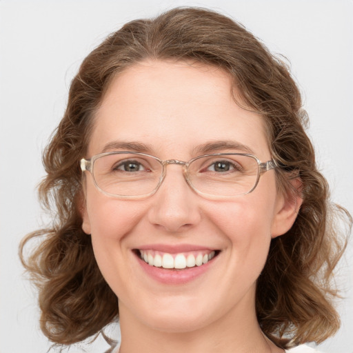 Joyful white adult female with medium  brown hair and green eyes