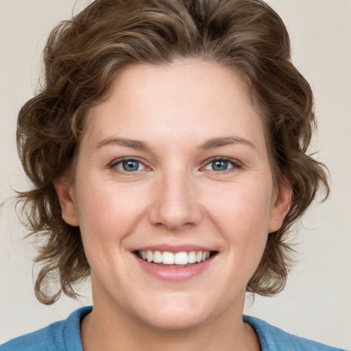 Joyful white young-adult female with medium  brown hair and blue eyes