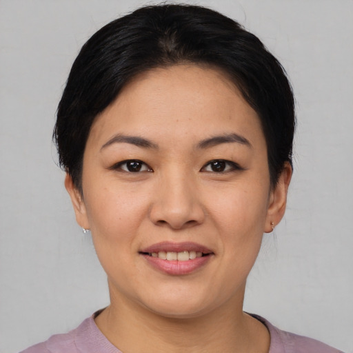 Joyful asian young-adult female with short  black hair and brown eyes