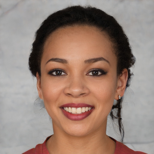 Joyful black young-adult female with short  black hair and brown eyes