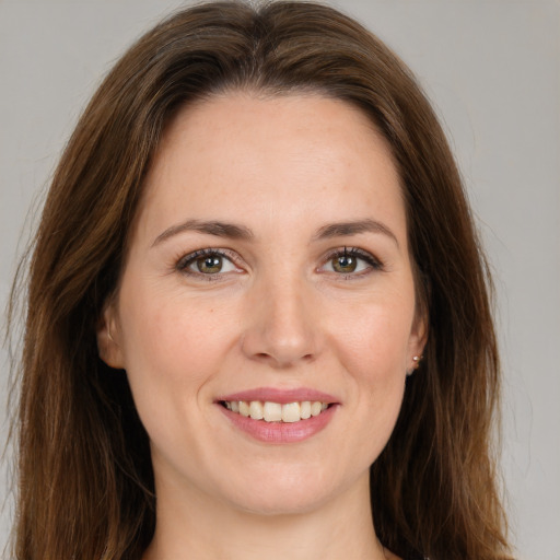 Joyful white young-adult female with long  brown hair and green eyes