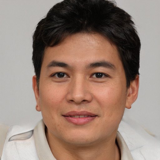 Joyful asian young-adult male with short  brown hair and brown eyes