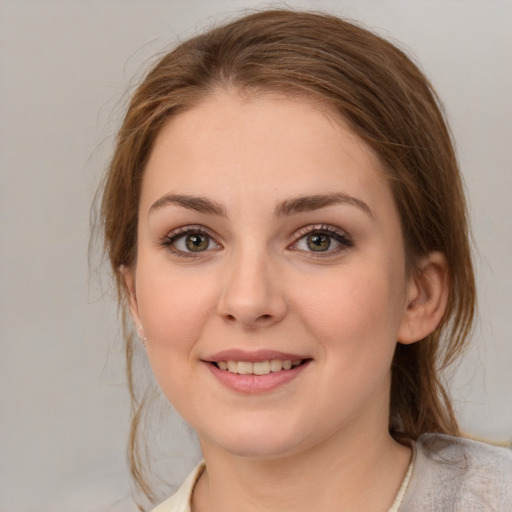 Joyful white young-adult female with medium  brown hair and green eyes