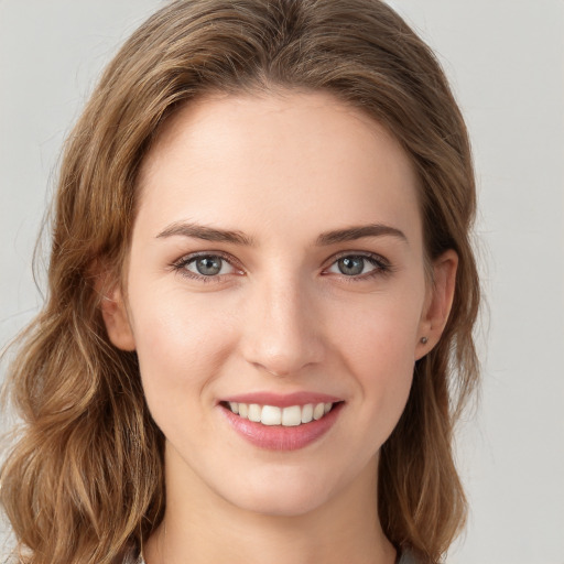 Joyful white young-adult female with long  brown hair and grey eyes