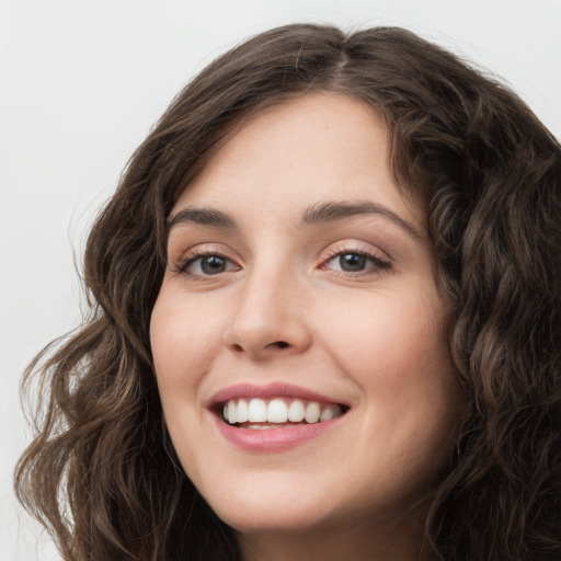 Joyful white young-adult female with long  brown hair and green eyes