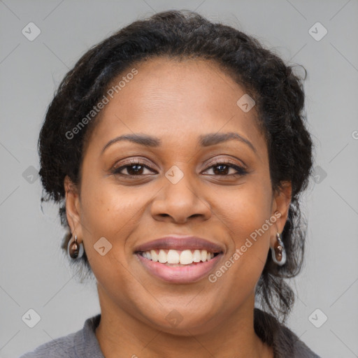 Joyful black adult female with medium  brown hair and brown eyes