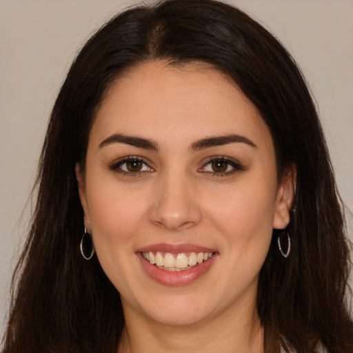 Joyful white young-adult female with long  brown hair and brown eyes