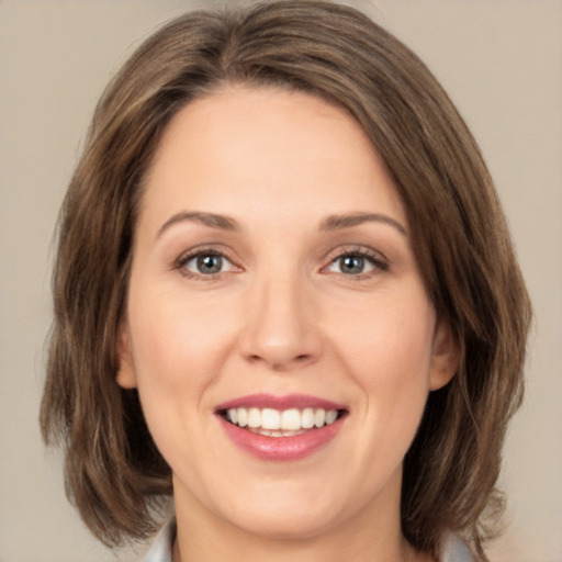 Joyful white young-adult female with medium  brown hair and green eyes