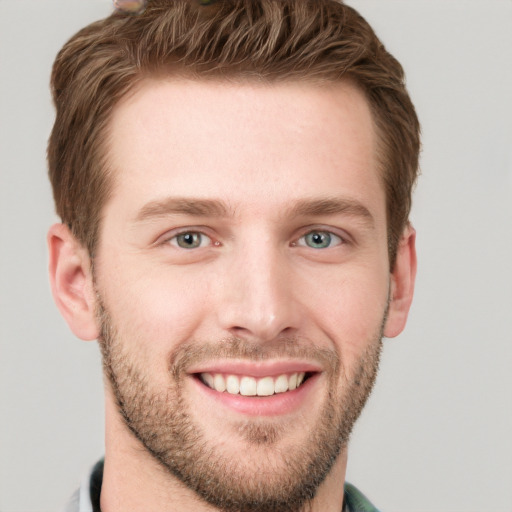 Joyful white young-adult male with short  brown hair and grey eyes